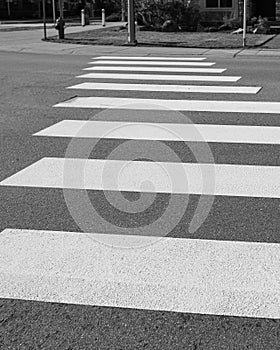 Pedestrian crossing, white stripes on black asphalt, road markings zebra crossing, place to cross the road.