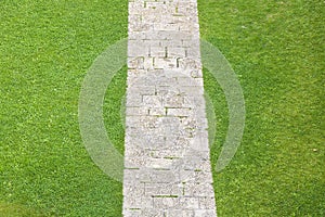 Pedestrian old stone footpath on a grass area of a public park