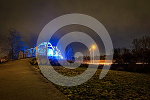 Pedestrian overpass lit up in bright blue LEDs at night