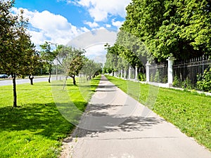 pedestrian pathway with green lawn and apple trees