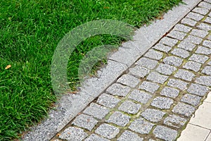 A pedestrian pavement made of stone cobble and granite tiles.