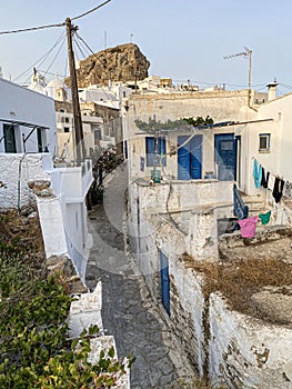 Pedestrian street of Greek Chora village built around a large rock on Amorgos island, Aegean Sea, Cyclades, Greece