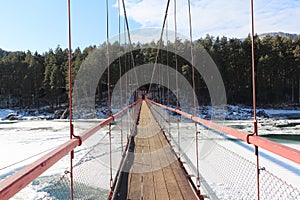 Pedestrian suspension bridge over the Katun River near the village  Barangol, Altai Republic, Russia