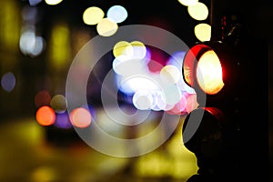 Pedestrian traffic light in the street junction in the city with beautiful bokeh lights in the night. Defocused