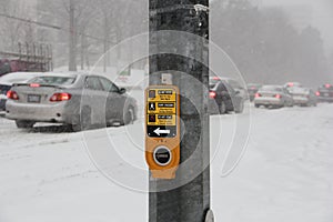 Pedestrian traffic stop button close up with snow storm on the background