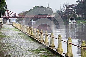 Pedestrian walk along the river, with the Carmelo bridge during a rainy day photo