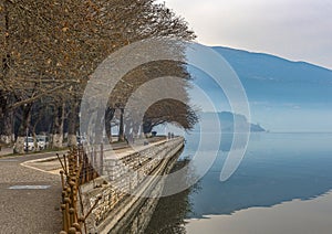 Pedestrian walkway for exercise or bikes lined up with beautiful tall trees in lake Pamvotis, Ioannina city. Greece