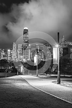 Pedestrian walkway in park and skyline of Hong Kong city at night
