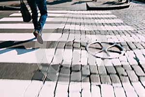 Pedestrian zebra on asphalt and paving stone