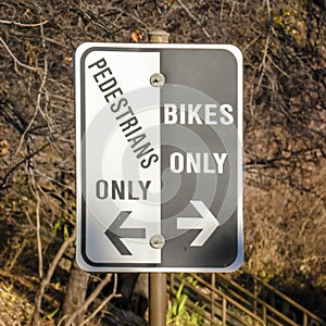 Pedestrians Only and Bikes Only sign against trees