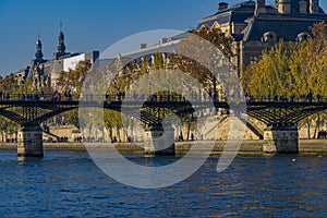 Pedestrians Bridge Over Seine River in Paris With Buildings and Autumn Color