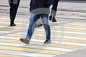 Pedestrians cross the street at a pedestrian crossing