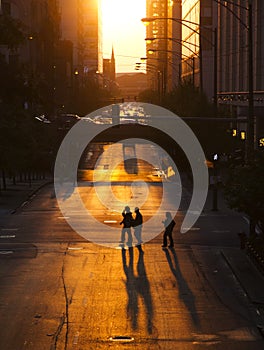 Pedestrians crossing street at sunset