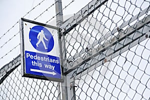 Pedestrians this way sign at entrance to factory and office workplace for direction with pointing arrow photo
