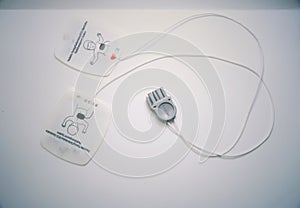 Pediatric combo pads used for defibrillation placed on a white background.