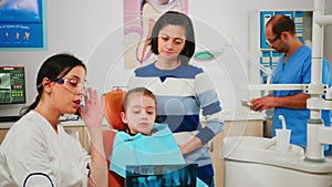 Pediatric dentist showing dental problems holding radiography