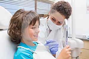 Pediatric dentist showing little boy his teeth in the mirror