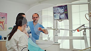 Pediatric dentist showing on monitor teeth x-ray
