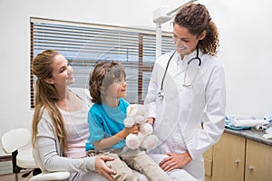 Pediatric dentist smiling at little boy with his mother