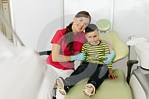 Pediatric dentistry. Little patient giving high five to doctor. Friendly dentist at work, dental office, oral hygiene