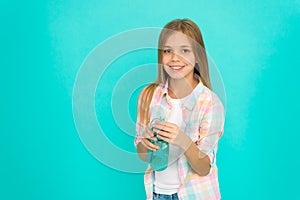 Pediatric disorders of water balance. Girl cares about health and water balance. Kid hold bottle blue background. Child
