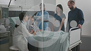 Pediatric doctor examining breathing sickness symptoms while african american nurse checking IV drip