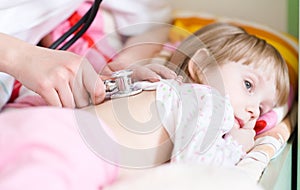 Pediatric doctor examining little baby girl photo