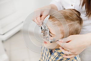 Pediatric Doctor ophthalmologist checks vision of child boy. Concept selection of glasses lenses.