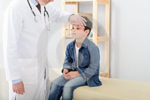 Pediatrician checking temperature of sick patient