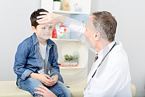 Pediatrician checking temperature of sick patient