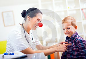 Pediatrician with clown nose and happy child patient