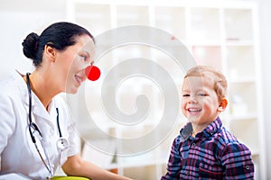 Pediatrician with clown nose and happy child patient