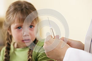 Pediatrician doctor applying syringe to child