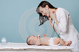 Pediatrician doctor communicates and plays with baby