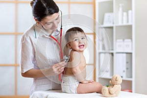 Pediatrician doctor examining heartbeat of baby with stethoscope