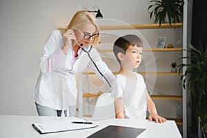 Pediatrician doctor examining little boy& x27;s heart beat and lungs to check for problems