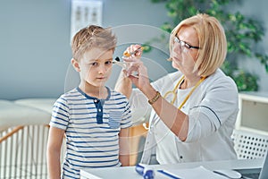 Pediatrician doctor examining little kids in clinic ears check