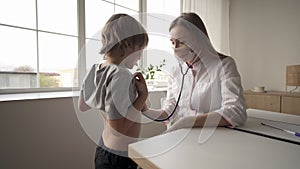 Pediatrician doctor woman uniform hold stethoscope annual check up toddler boy by monitoring heart pulse rate