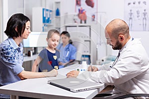 Pediatrician doctor writing symptoms disease after consultation