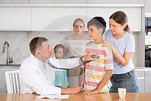 Pediatrician examinating pre-teen boy