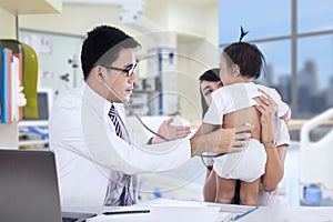 Pediatrician examines baby with stethoscope