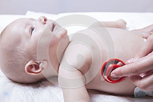 Pediatrician examines newborn baby boy with stethoscope