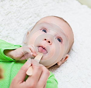 Pediatrician examines a newborn baby with a spatula