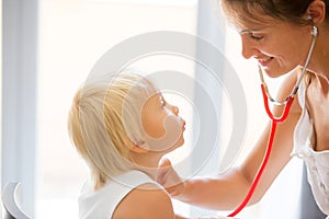 Pediatrician examining baby boy. Doctor using stethoscope to listen to kid and checking heart