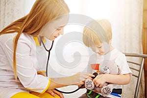 Pediatrician examining baby boy. Doctor using stethoscope to listen to kid and checking heart beat