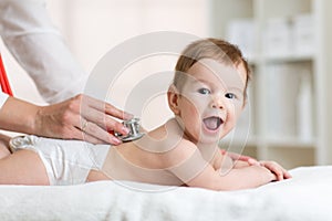 Pediatrician examining baby. Doctor using photo