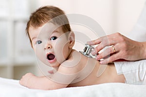 Pediatrician examining baby with stethoscope