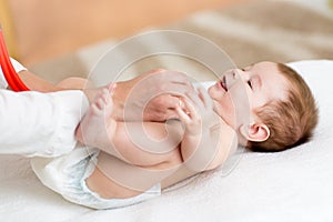 Pediatrician examining baby with stethoscope