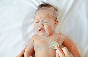 Pediatrician examining baby with a stethoscope