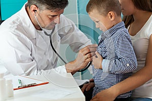 Pediatrician examining boy lungs